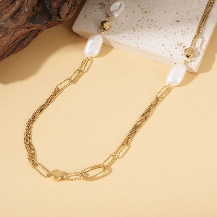 Guldfarvet lang halskæde med flere teksturerede kæder pyntet med perler for engroshandel hos joya