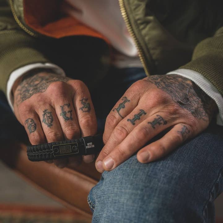 The Hero Company - Wholesale Woven/Braided Bracelet - Never Forgotten Black Paracord Bracelet: Helps Pair Veterans With A Service Dog Or Shelter Dog -Faire2