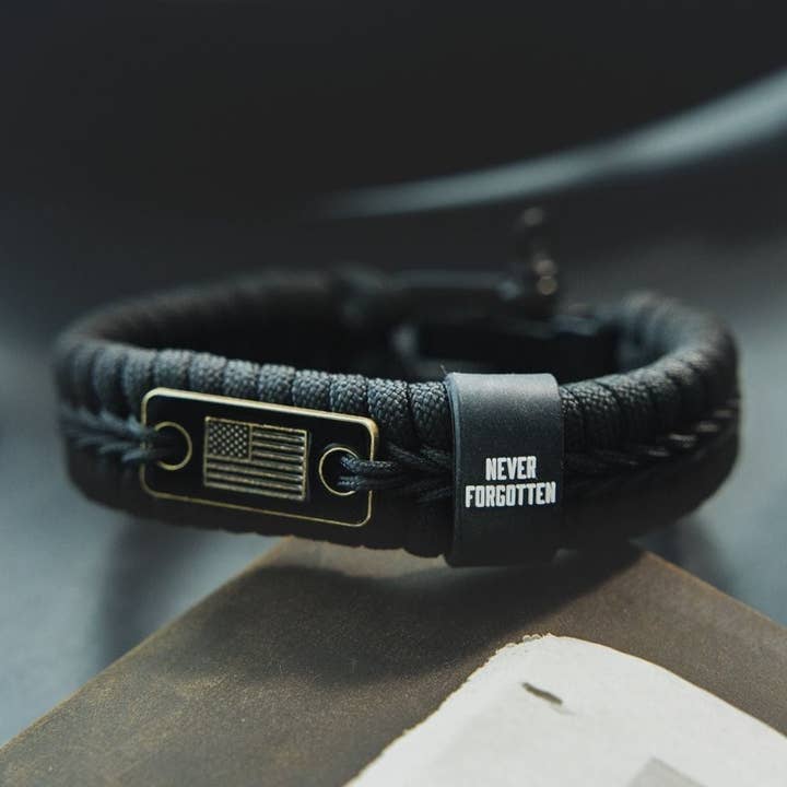 The Hero Company - Wholesale Woven/Braided Bracelet - Never Forgotten Black Paracord Bracelet: Helps Pair Veterans With A Service Dog Or Shelter Dog -Faire