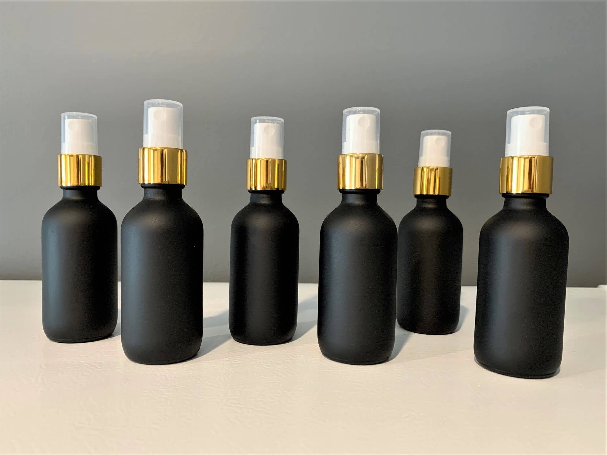 The Bottle Shoppe – Engroshandel Holder til æterisk olie – 2 oz sort mat glasflaske med gylden fin spray1