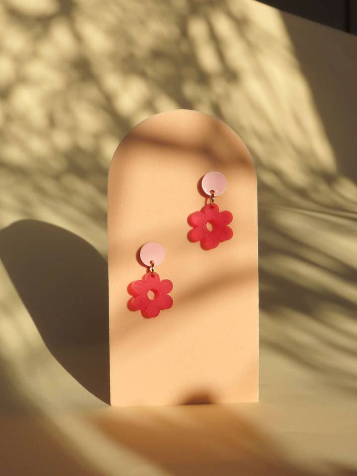 Øreringe med enkelt margerit i akryl og rustfrie stålstifter i lyserød og rød for engroshandel hos Niemalsmehrohne