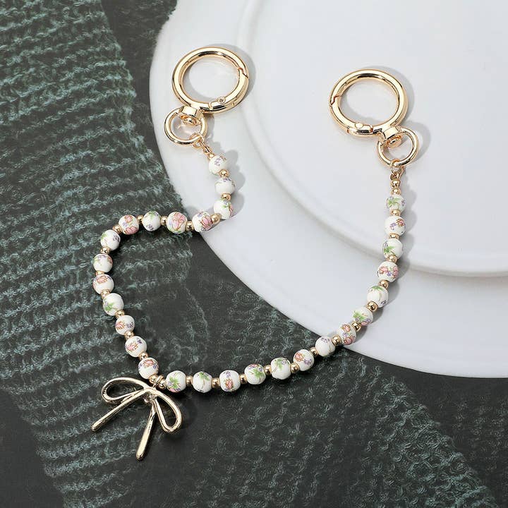 Metal Bow Charm Pointed Floral Ceramic Ball Beaded Bag Charm for wholesale by Sensibling Corp.