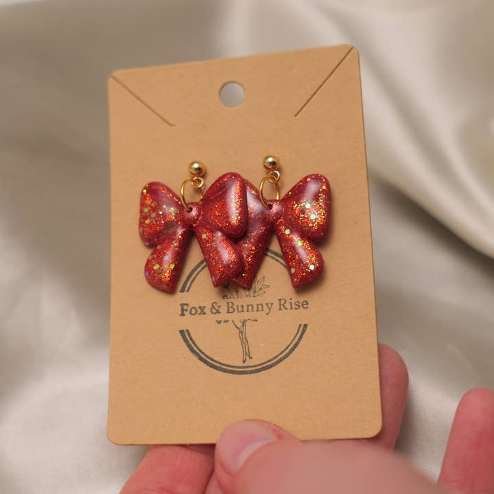 Glossy Glittery Red Bow Dangle Earrings for wholesale by Fox and Bunny Rise