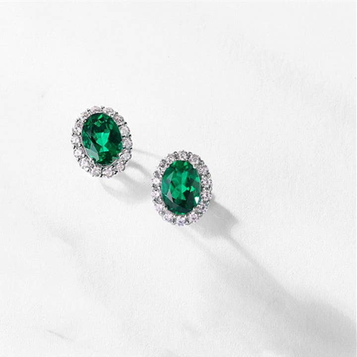 Oval Cut Emerald Halo Stud Earrings in 925 Sterling Silver for wholesale by Perimade & Co. LLC