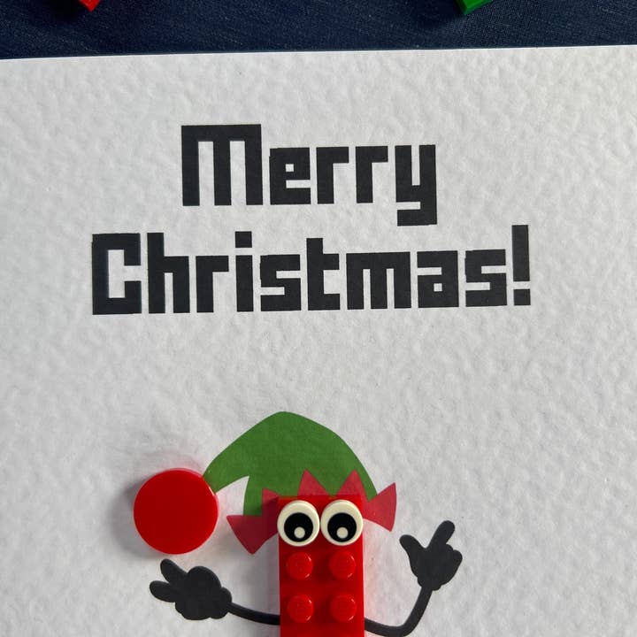 Stud Universe – Großhandel Weihnachtskarte – Festliche LEGO-Karte mit frecher Elfe aus LEGO-Stücken
