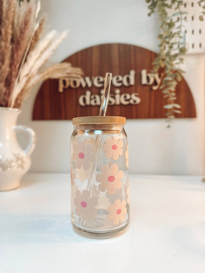 Tasse en verre beige à marguerites avec couvercle et paille pour la vente par Powered By Daisies