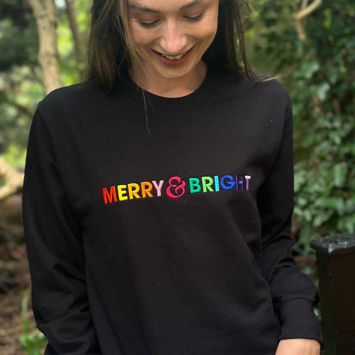 Merry & Bright Rainbow Embroidered Christmas Sweatshirt in Black for wholesale by Percy and Nell Retail Limited