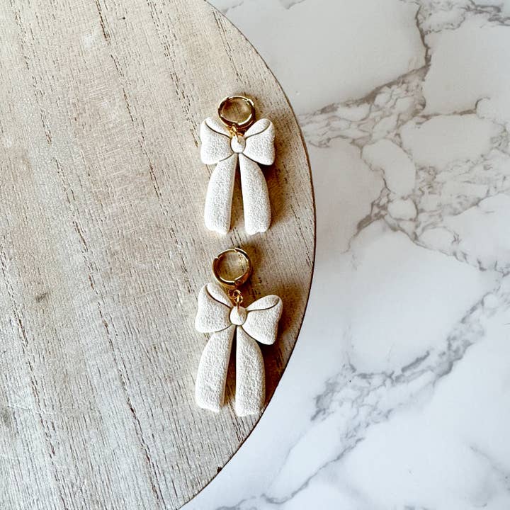 Bow Huggies, mandelsand | Handgjorda polymerlera örhängen för wholesale av Britt Cimone