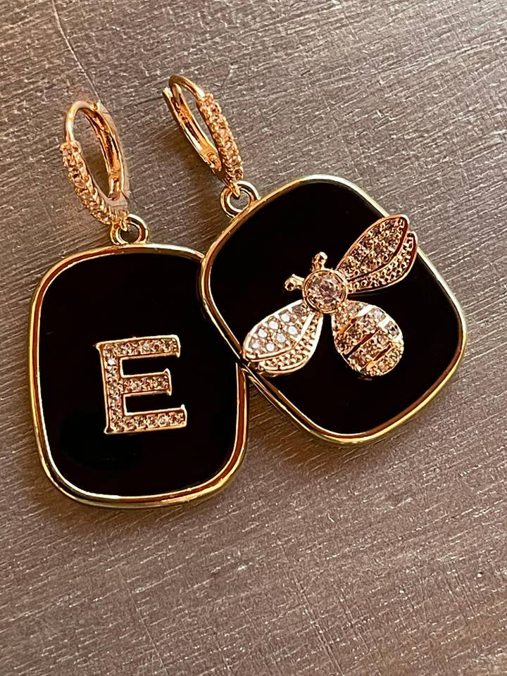 SCHWARZE OHRRINGE MIT BUCHSTABEN- UND APINAPLATTEN für den Großhandel von LARA UNDICI ACCESSORI SRLS