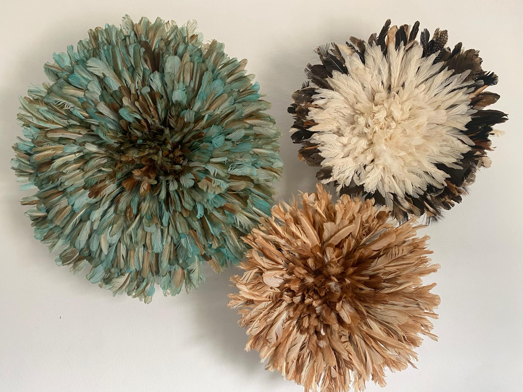 Juju hat world - Venta al por mayor Papel pintado 3D - Conjunto de tres sombreros juju. Decoración de plumas beige, verde petróleo y blancas.