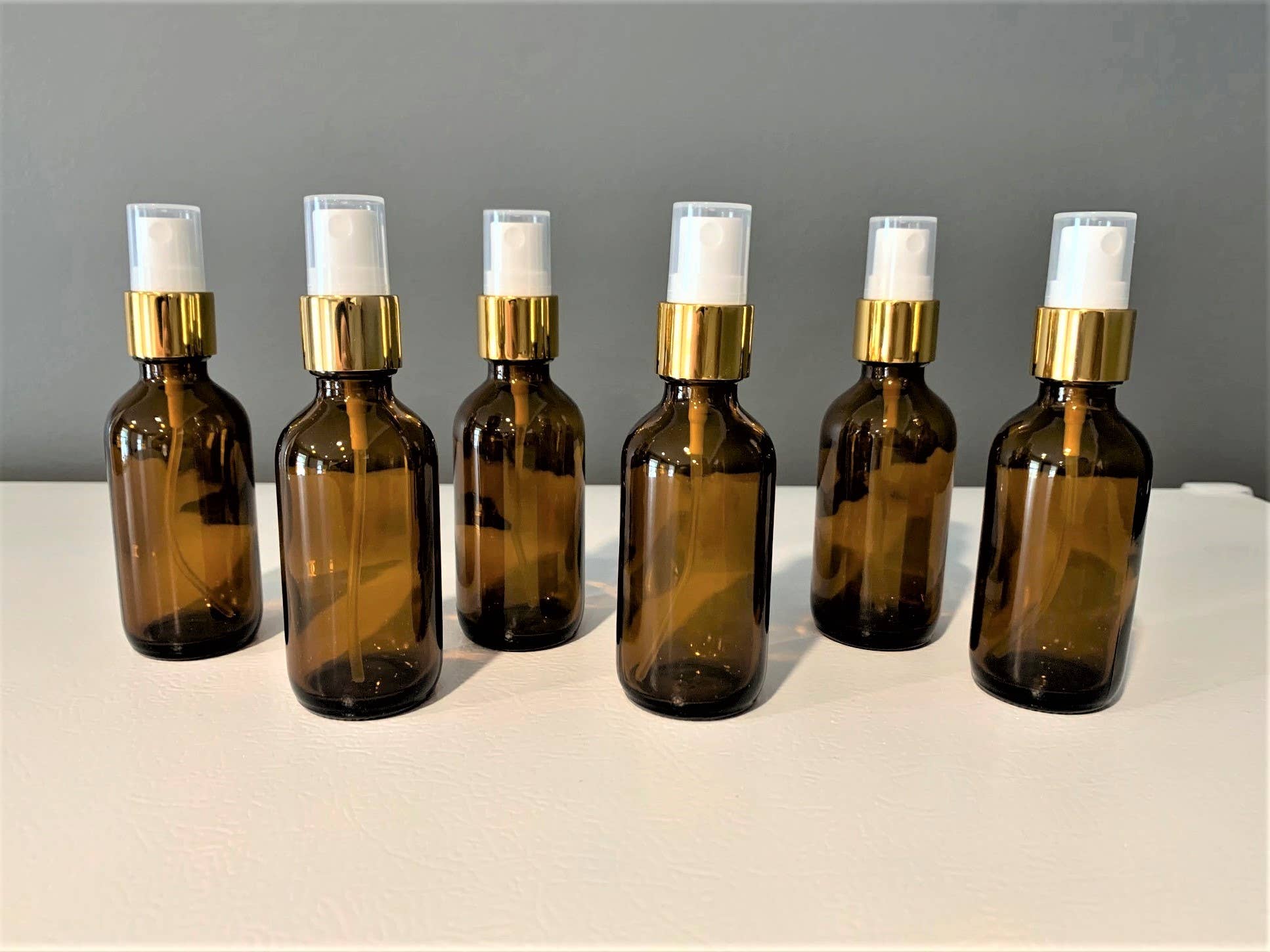 The Bottle Shoppe - Wholesale Essential Oil Holder - 2oz Amber Glass Bottle with Gold Fine Mist Sprayer1