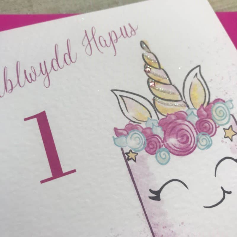 White Cotton Cards - Wholesale Birthday Card - Welsh Age 1 - Unicorn Cake (W-R101-1)1