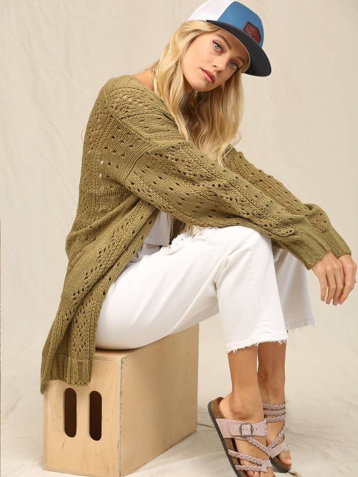 Ce cardigan tricoté avec des points ajourés. pour la vente par KyeMi