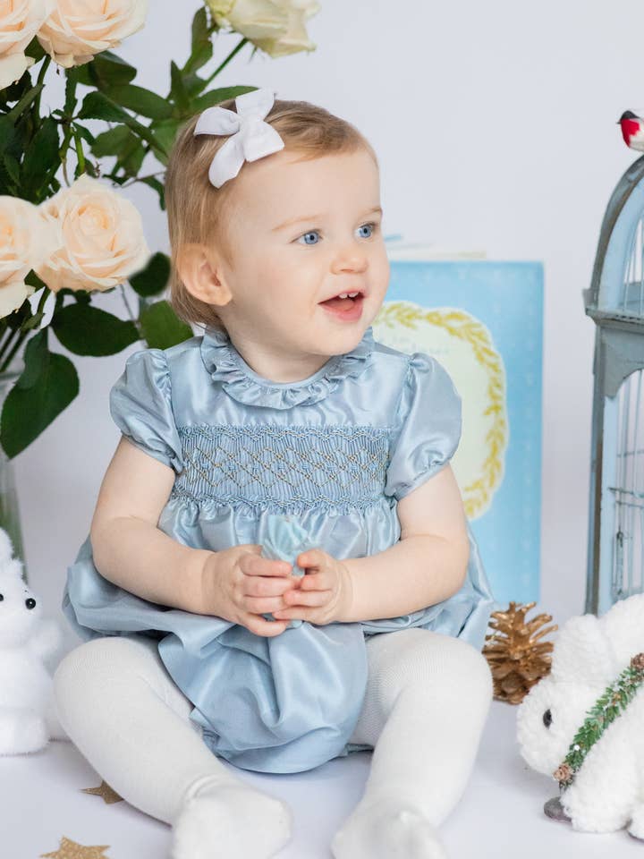 Bulle de bébé smockée en soie bleue Astrid pour la vente par Antoinette Paris