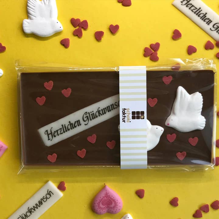 Milk chocolate congratulations with sugar hearts for wholesale by Schokifaktur