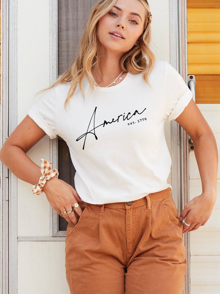 T-Shirt Gráfica AMÉRICA EST. 1776 por atacado de OAT COLLECTIVE