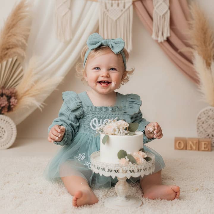 Baby Teal Long Sleeve Smocked “One” Birthday Romper Dress for wholesale by Rufflеѕ & Bоwtіеѕ - Affordable Boys & Girls Clothing