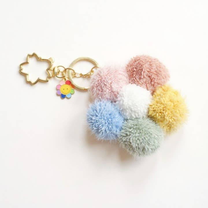 Multicolor Pom Pom Keychain with Gold Flower Charm and Smiley Accent and other Purchase Wholesale fluffy keychain. Free Returns & Net 60 Terms on Faire trending on Faire.
