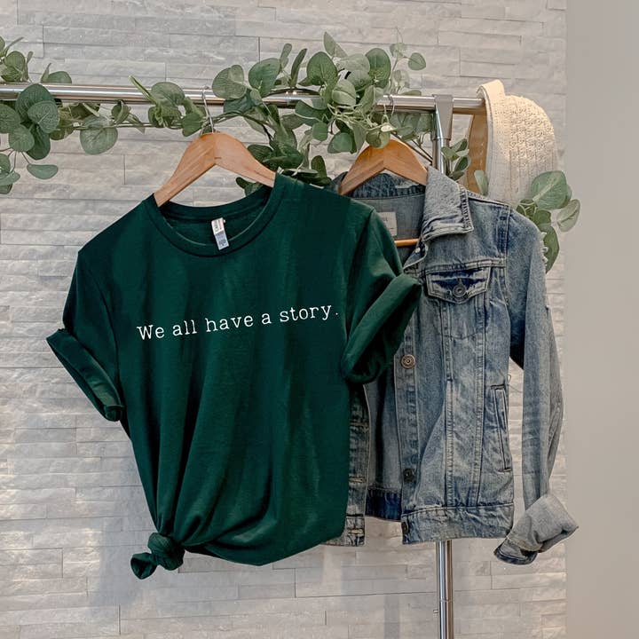 "Vi har alle en historie" Unisex T-shirt – Omfavn din fortælling for engroshandel hos Say Hello Threads