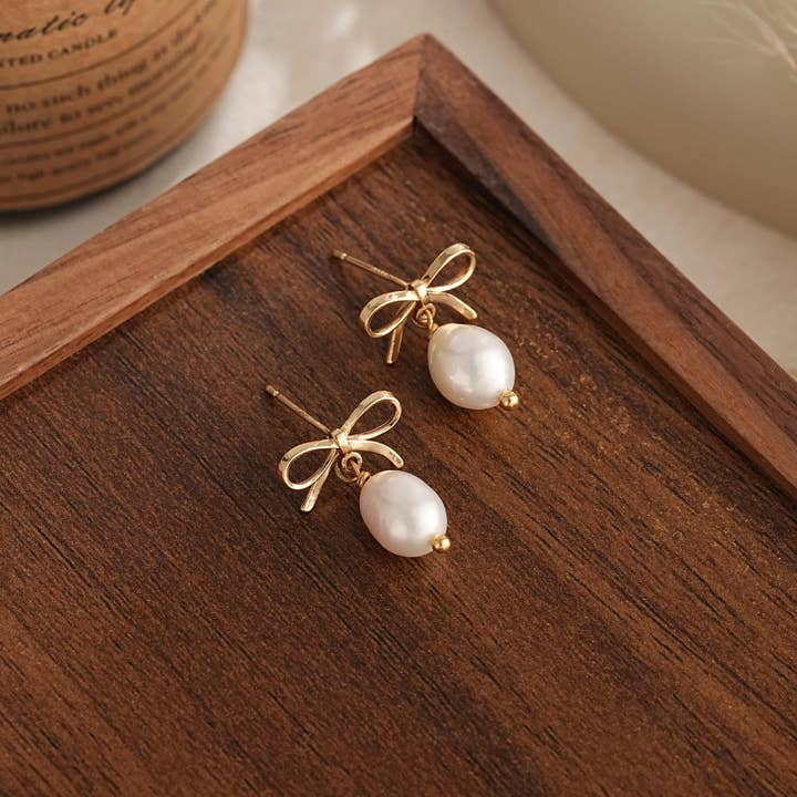 Pendientes de gota con perlas de agua dulce y lazo dorado Coquette Studs para venta al por mayor de Drrtymagic