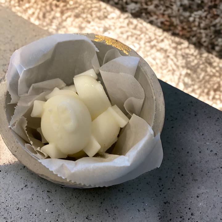 Cire de porcelet fondue dans un récipient en béton pour la vente par Grouchy Piglet