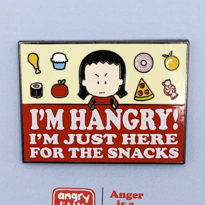 "I'm HANGRY! I'M JUST HERE FOR THE SNACKS" enamel pin for wholesale by Angry Little Girls