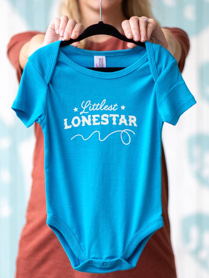 Il più piccolo body per neonati Lonestar per la vendita all'ingrosso da parte di Girl Riot Society by Mosaic Makers Co