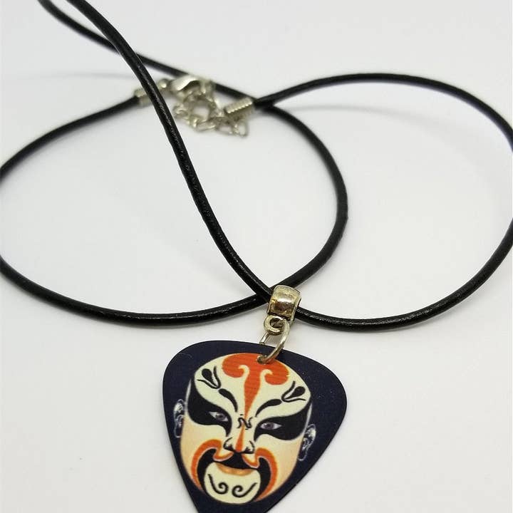 Simply Raevyn – Großhandel Kette mit Anhänger/Charm – Gitarrenplektrum mit chinesischer Opernmaske und schwarzer Kordelkette