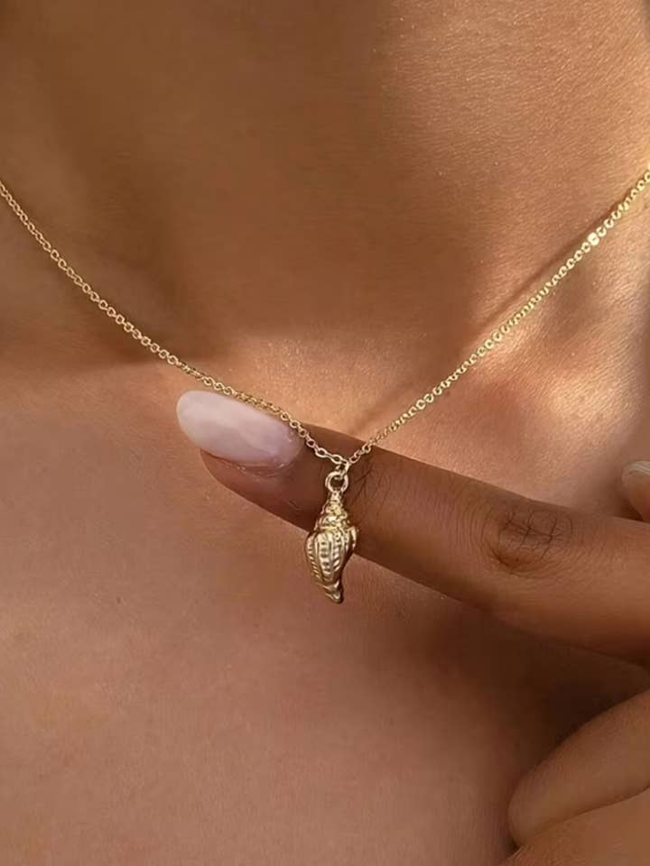 Collier en or avec coquillage. pour la vente par The Coconut Collective