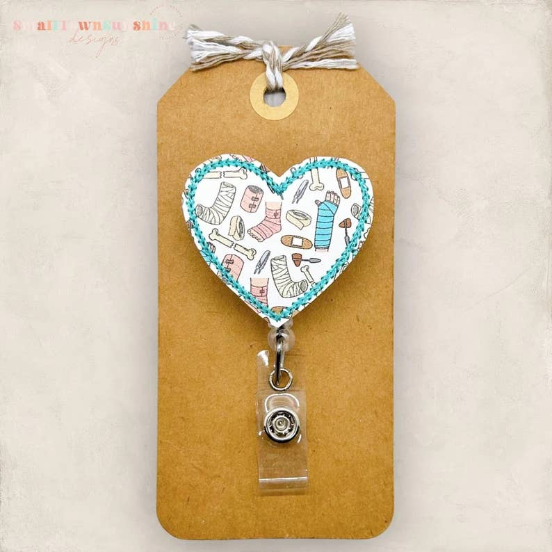 The SmallTownSunshine Company – Großhandel Ausweiszubehör – Damen – Broken Bones & Casts Abzeichenrolle mit Herzmotiv