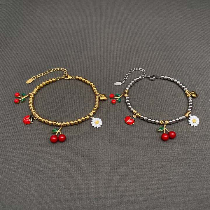 Bracciale in acciaio inox dorato 18K con coccinelle, ciliegie e fiori - FGS per la vendita all'ingrosso da parte di Mio Queena