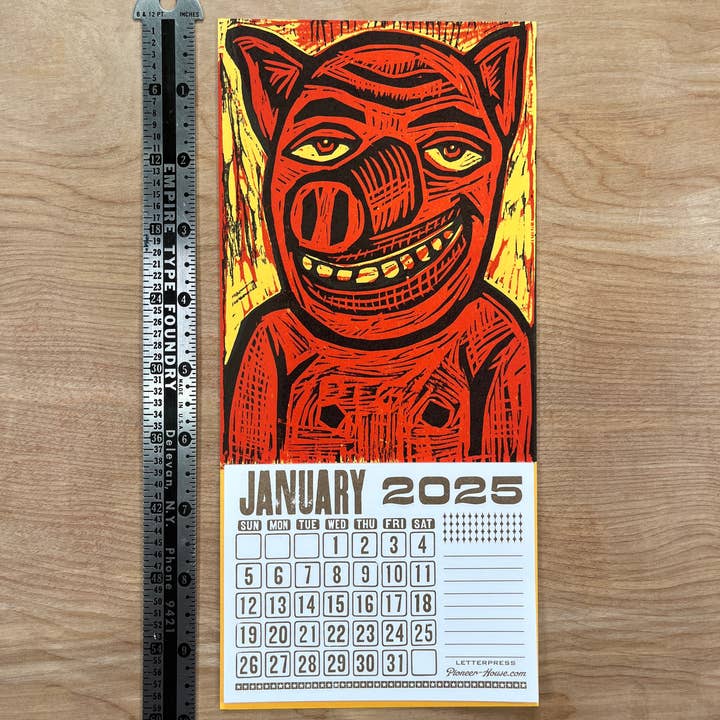 Pioneer House (formerly Yee-Haw) - Wholesale Calendar - 2025 Smiling Pig Woodcut Mini Calendar