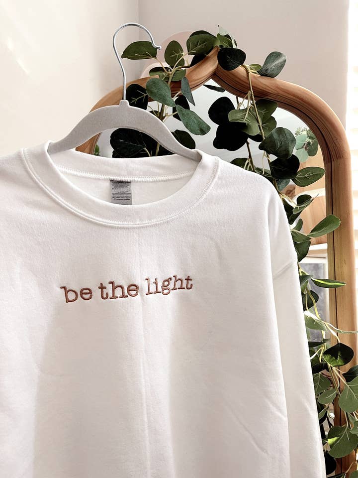 Geborduurd 'Be The Light'-sweatshirt voor wholesale door Honey Soul LLC