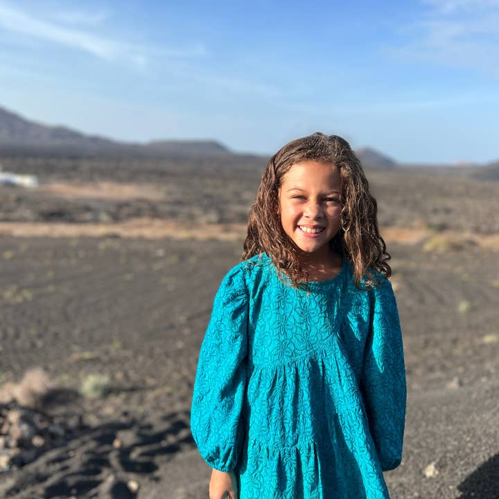 Asymmetric cascade dress in turquoise embroidered fabric for wholesale by Poppet & Fox