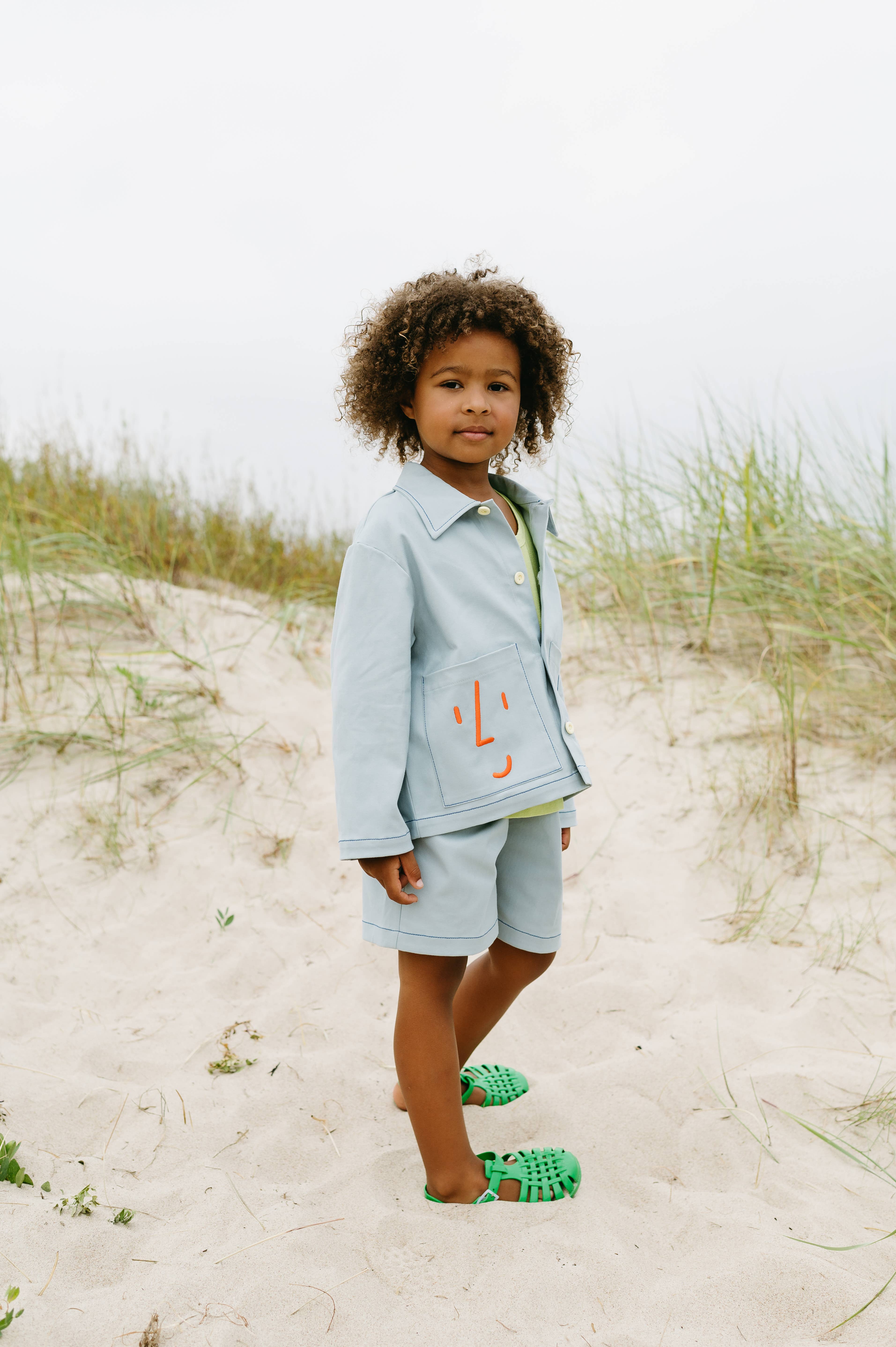 Blauw Utility jas met speelse geborduurde gezichten voor groothandel op Faire6