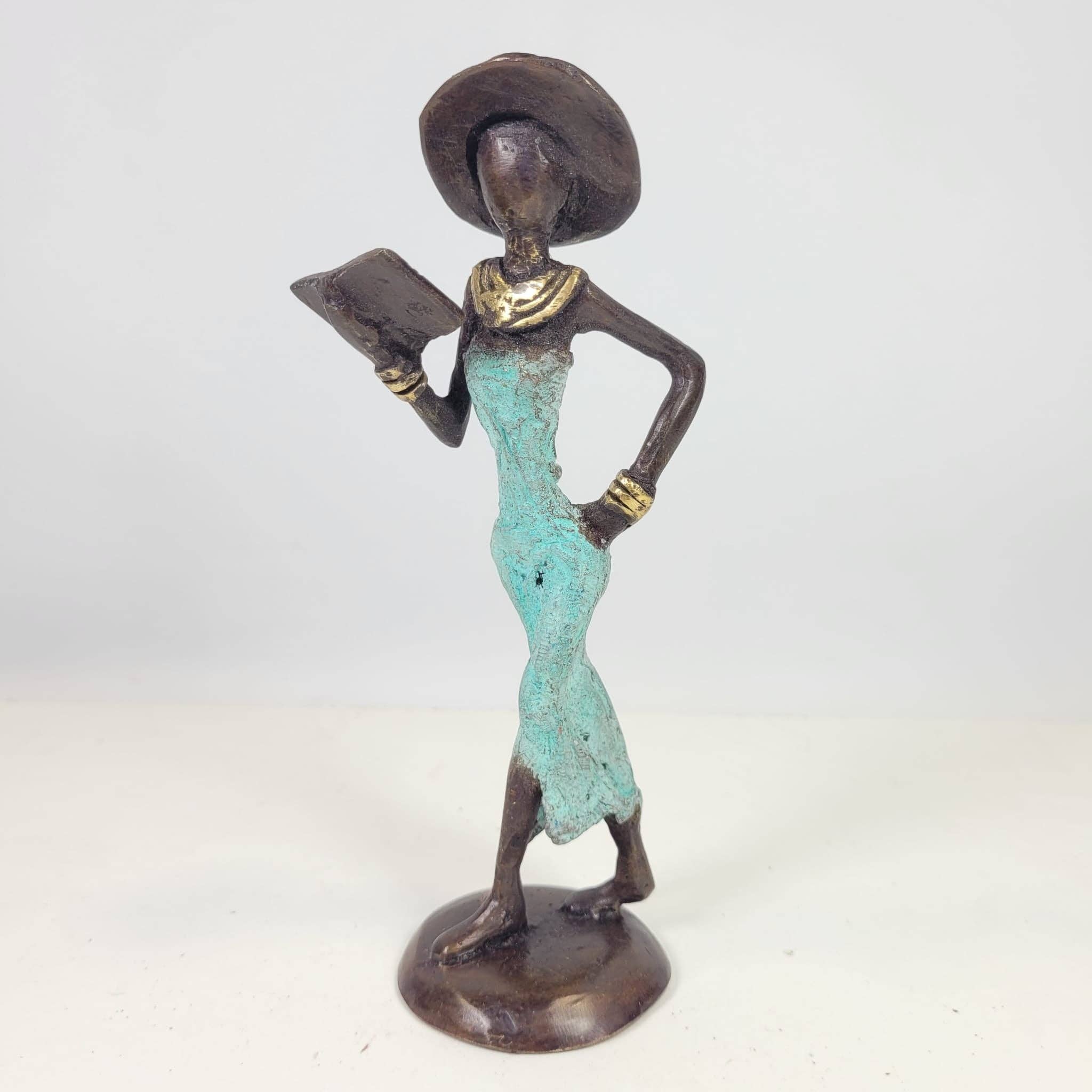 Moogoo Creative Africa - Wholesale Sculpture - Bronze sculpture “Femme avec livre et chapeau” by Soré | vers10