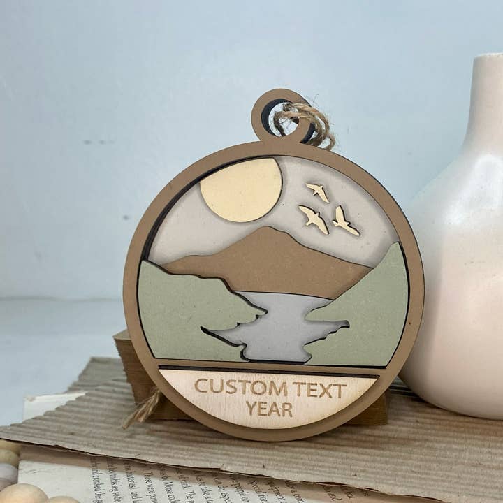 Pine Designs - Wholesale Ornament - Any CityState or CustomText Mountains w Creek Ornament