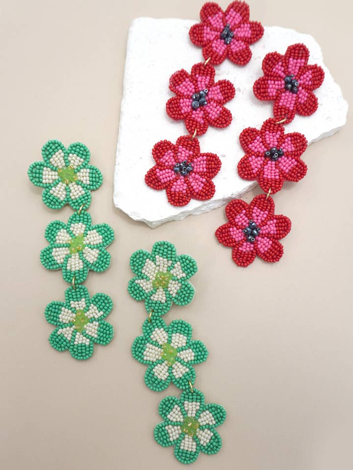 BRINCOS PENDENTES COM TRÊS FLORES E CONTAS 91E5647 por atacado de JOSSLYN by wall to wall