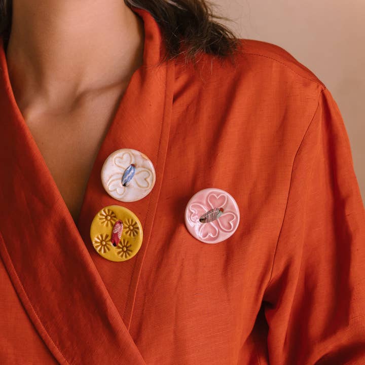 Spilla "Ti porti un bottone al petto" per la vendita all'ingrosso da parte di Passaro de Seda