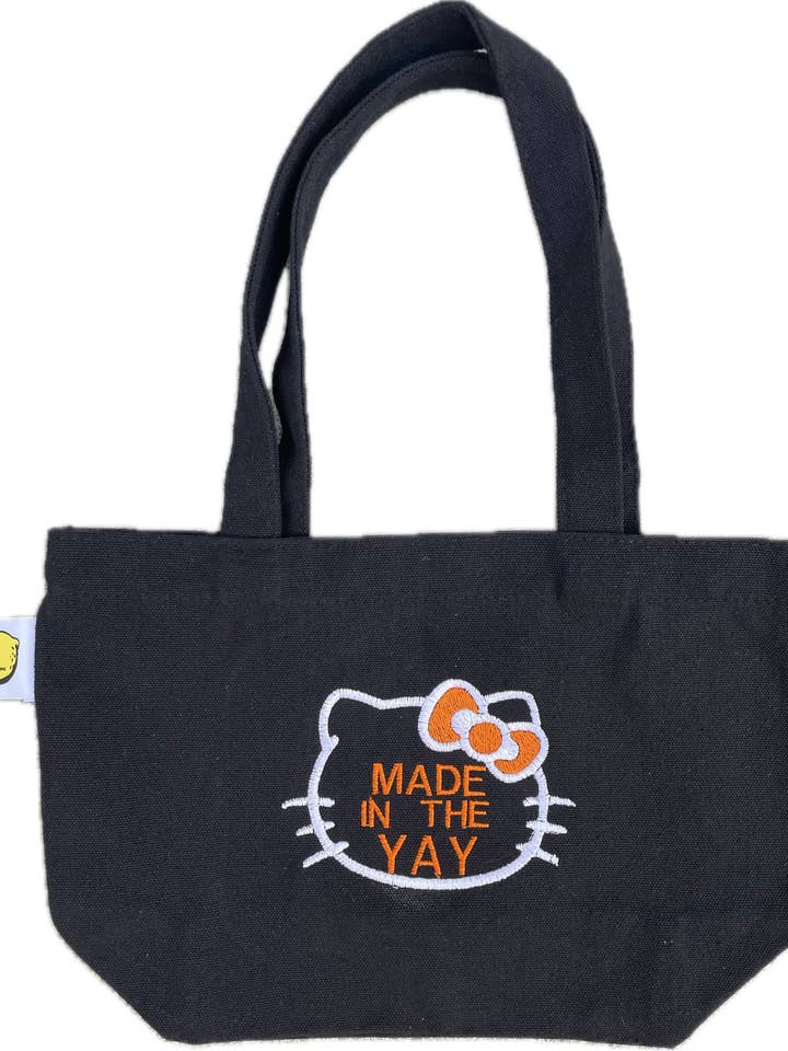 HK Made In The Yay Mini zwarte draagtas (wit/oranje tinten) voor wholesale door Lemonade51o