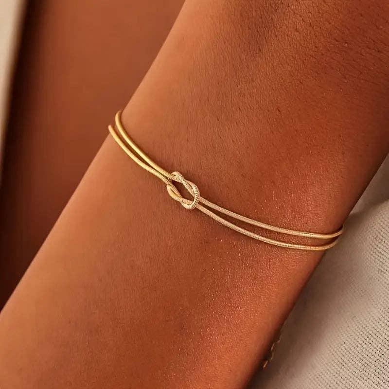 Huis Van Merken - Wholesale Bedelarmbandje - Eenvoudige en stijlvolle roestvrijstalen knooparmband voor koppels, verguld in gouden kleur0