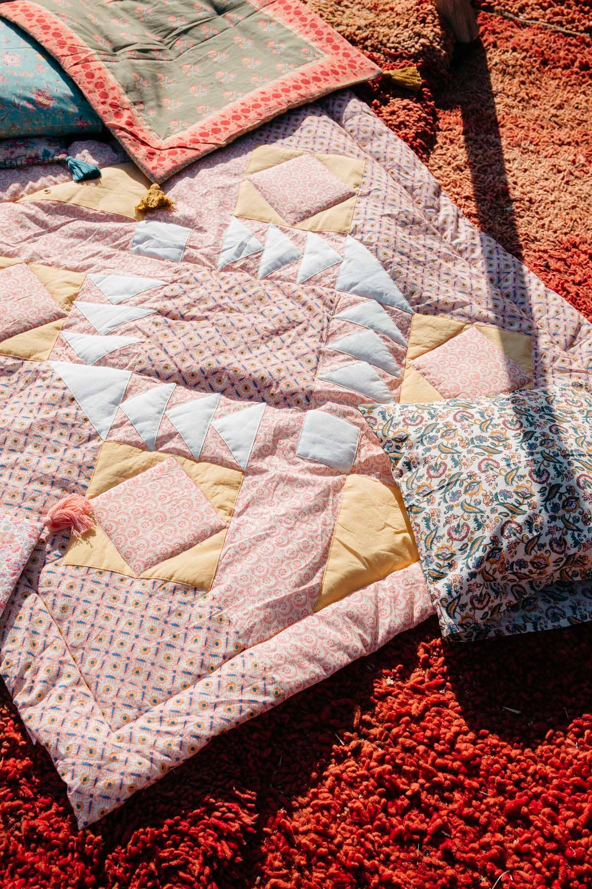 Patchwork Rosa Manta Aneka xadrez com patchwork, flores em tons rosa e amarelo para venda a revendedores na Faire1