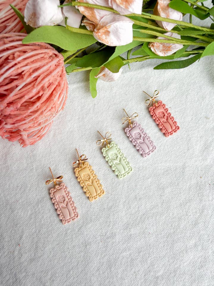 Boucles d'oreilles en pâte polymère embossées à motif de fleur avec cadre festonné pastel pour la vente par Morning Dew Designs
