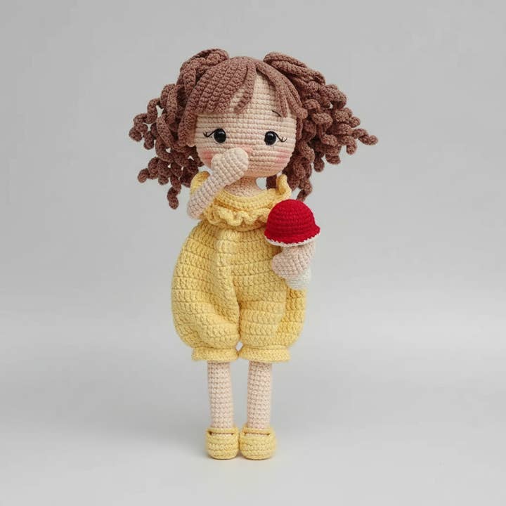 Handgemaakte gehaakte pop in gele jumpsuit met haar paddenstoelenspeeltje voor wholesale door Joy Gift London