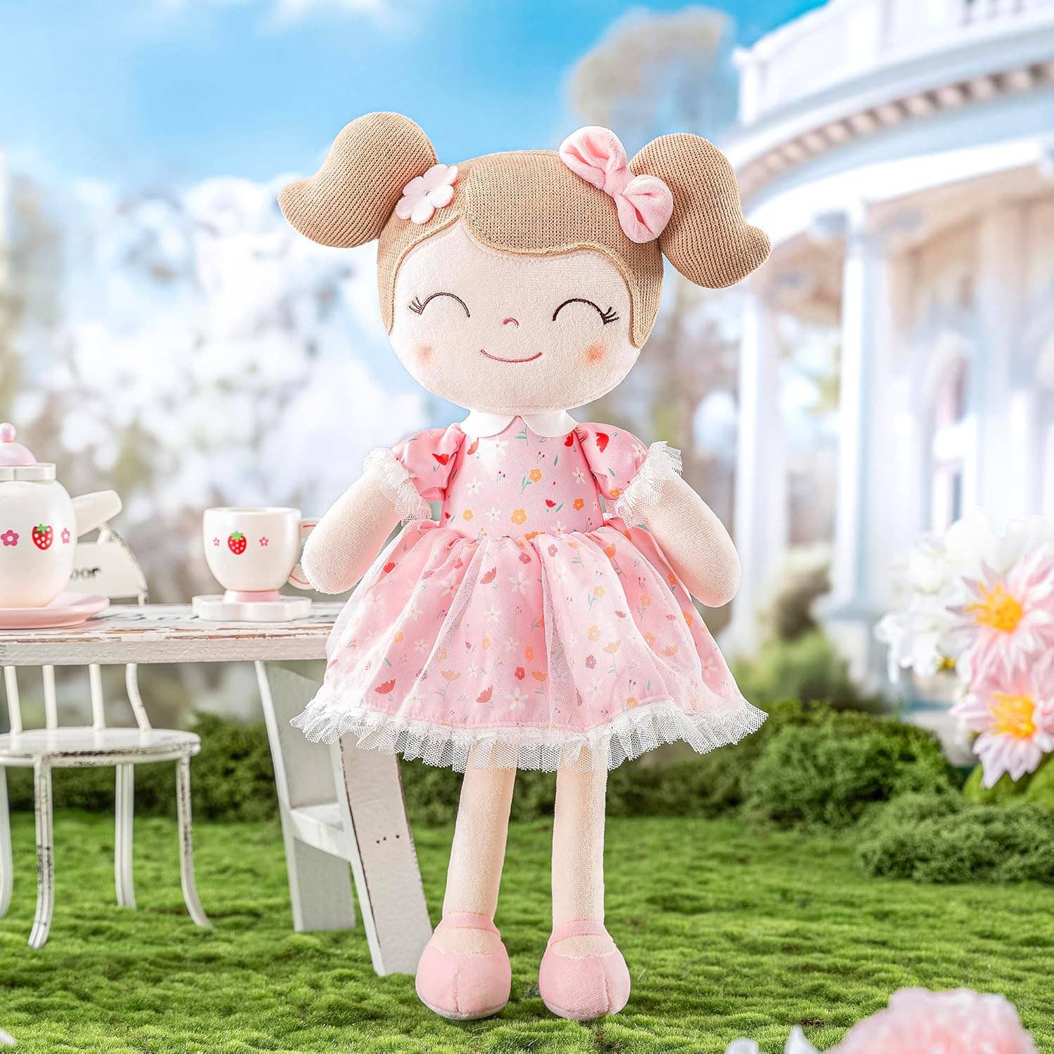 Tiny Tots Boutique – Engroshandel Dukke - Børn – Lyserød blomsterplysdukke med lysebrunt hår1