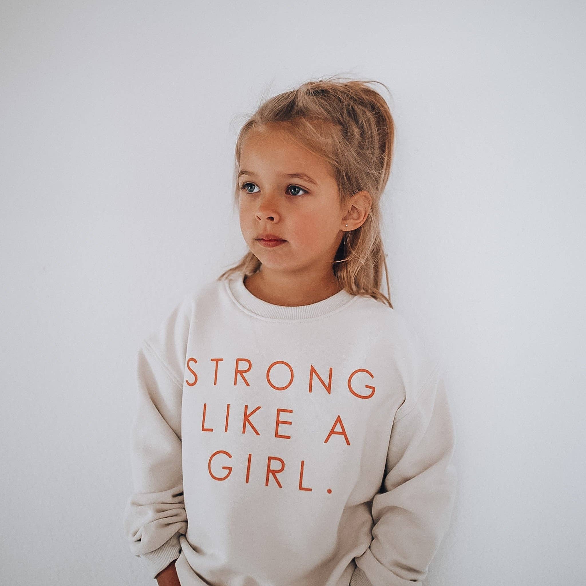 Minimalist Folk Co. – Großhandel Sweatshirt – Kinder – STARK WIE EIN MÄDCHEN Pullover | in Pfirsich | oversized mit überschnittener Schulter | KINDER2