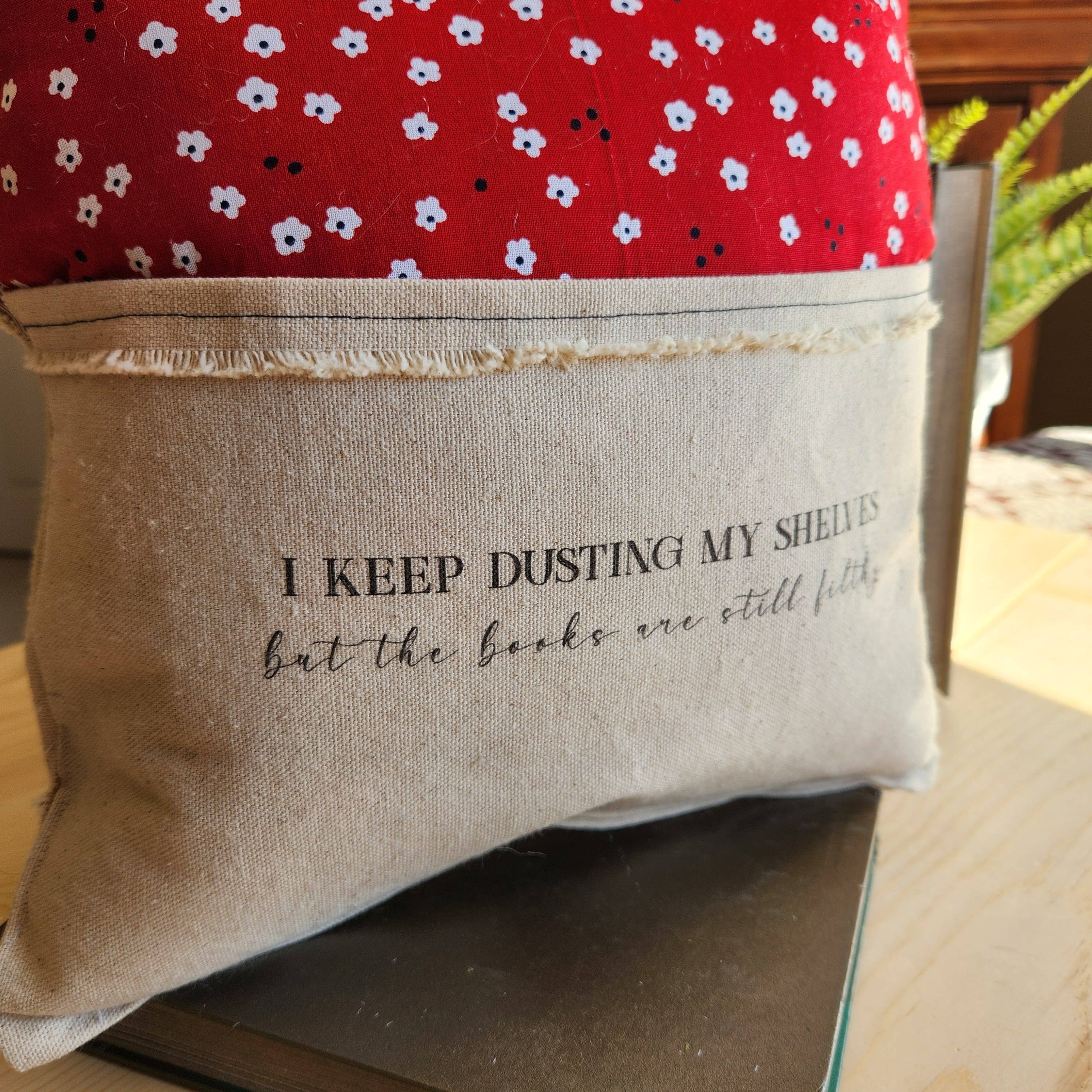 Desmond Brown - Vente Oreiller de voyage - Je continue à épousseter..., Coussin de lecture, rouge avec fleur blanche1