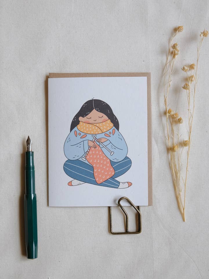 Knitting a Scarf Greeting Card for wholesale by Justine Gilbuena