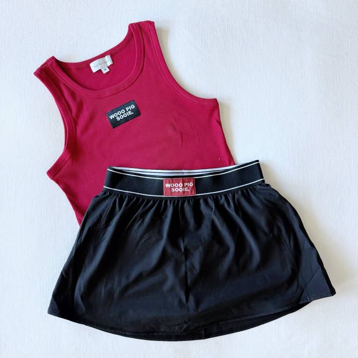 The Alli Airy Tennis Skort Black| Woo Pig Sooie Woven Label for wholesale by Scarlet & Gold