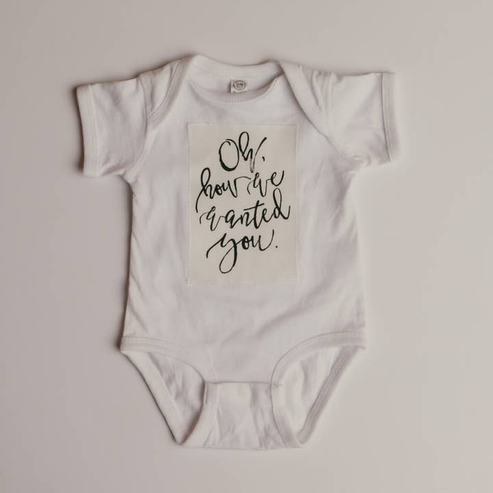 Onesie „Oh hoe we je wilden” - WIT voor wholesale door Modern Roots Kids Co.